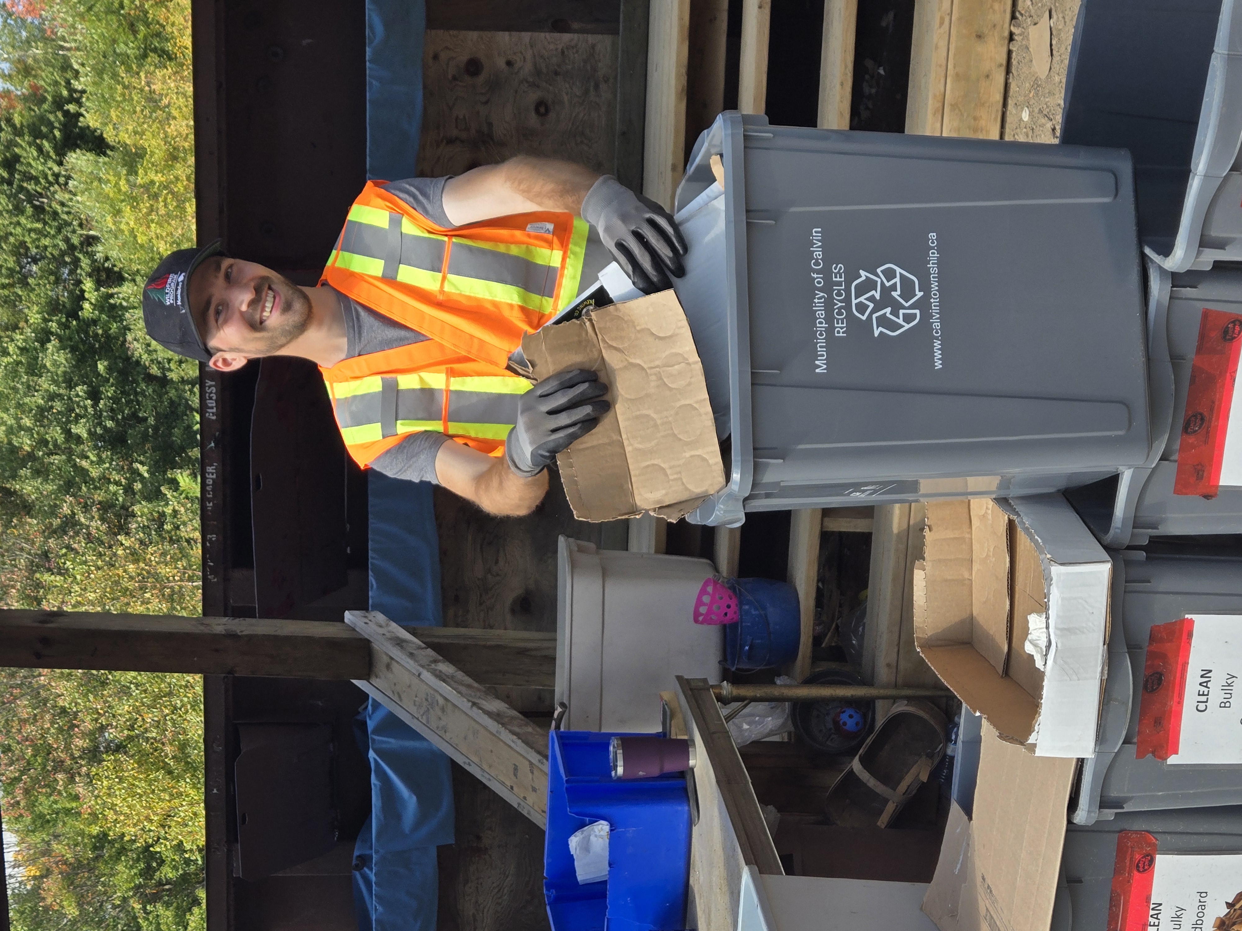 A landfill attendant demonstrates the Municipality of Calvin's new grey and blue bin program.