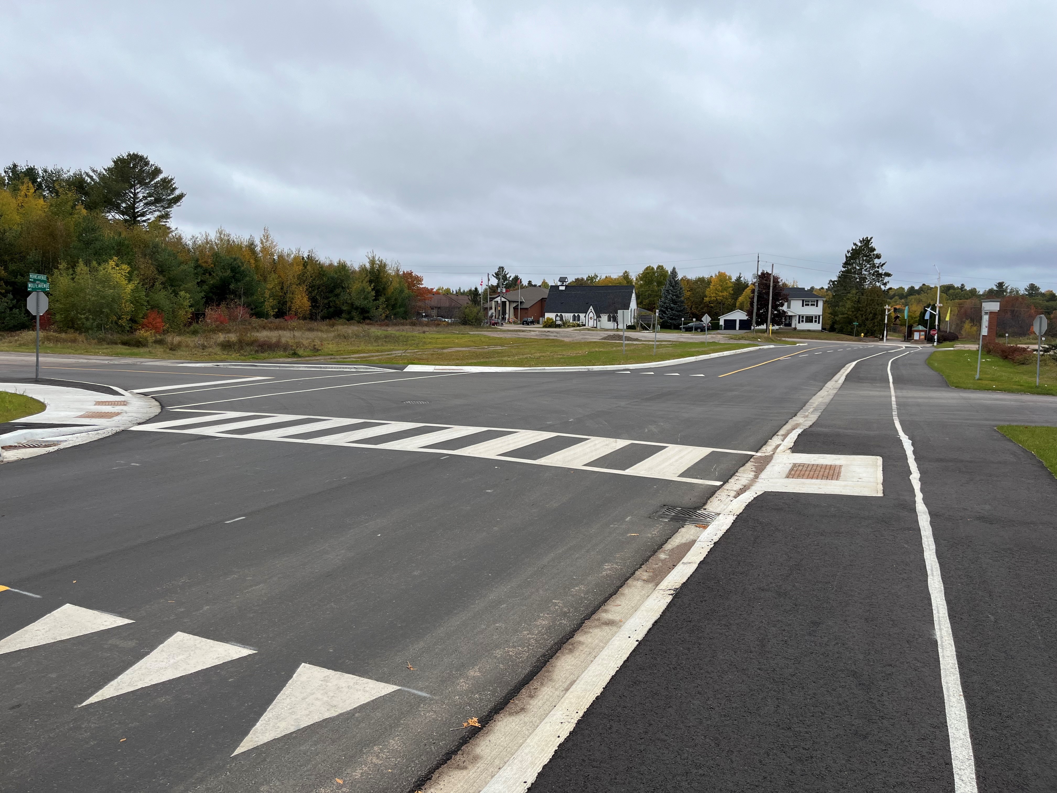 A roadway with white painted lines under an overcast sky. 