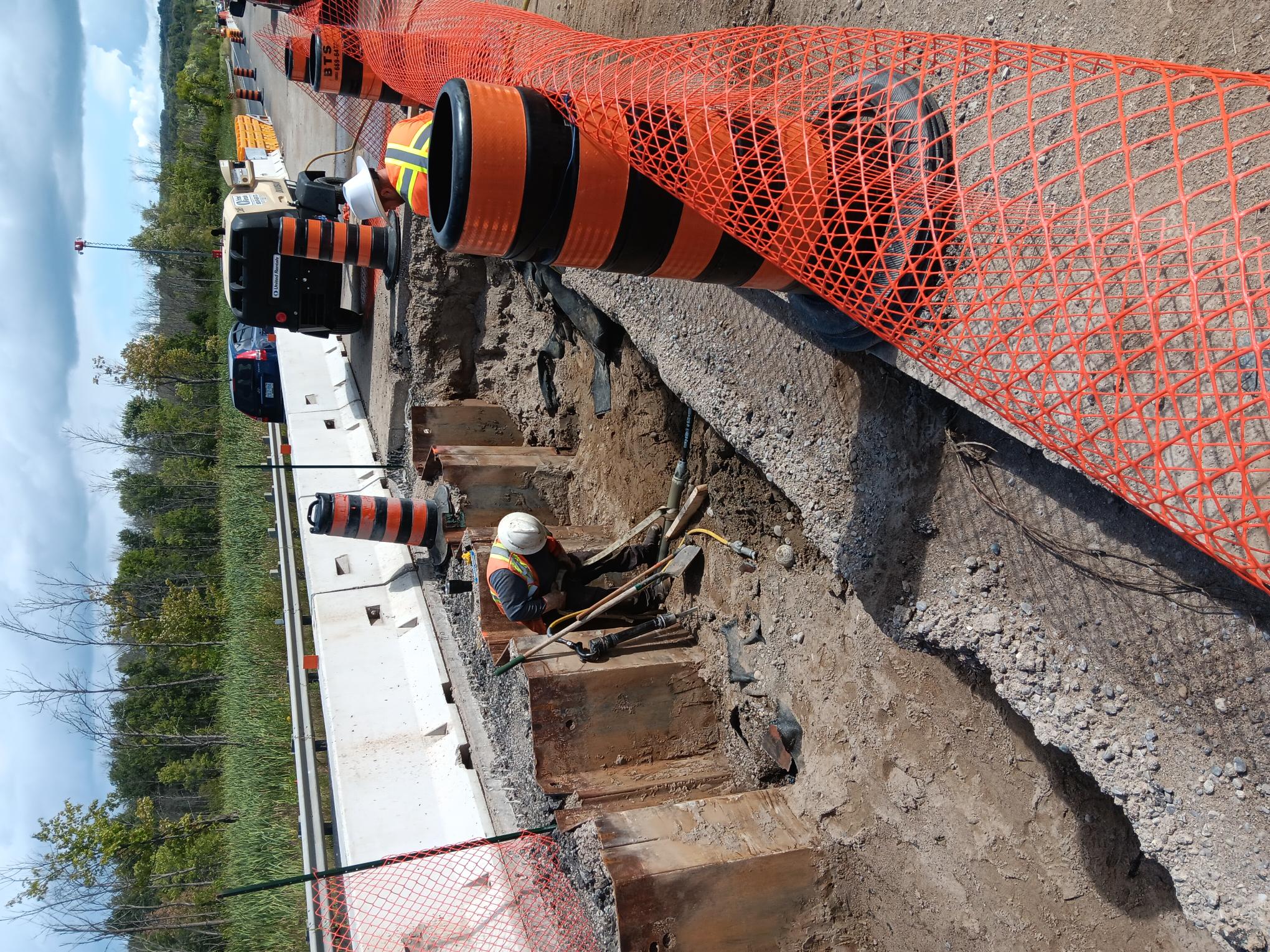 A construction worker working on a bridge surrounded by pylons.