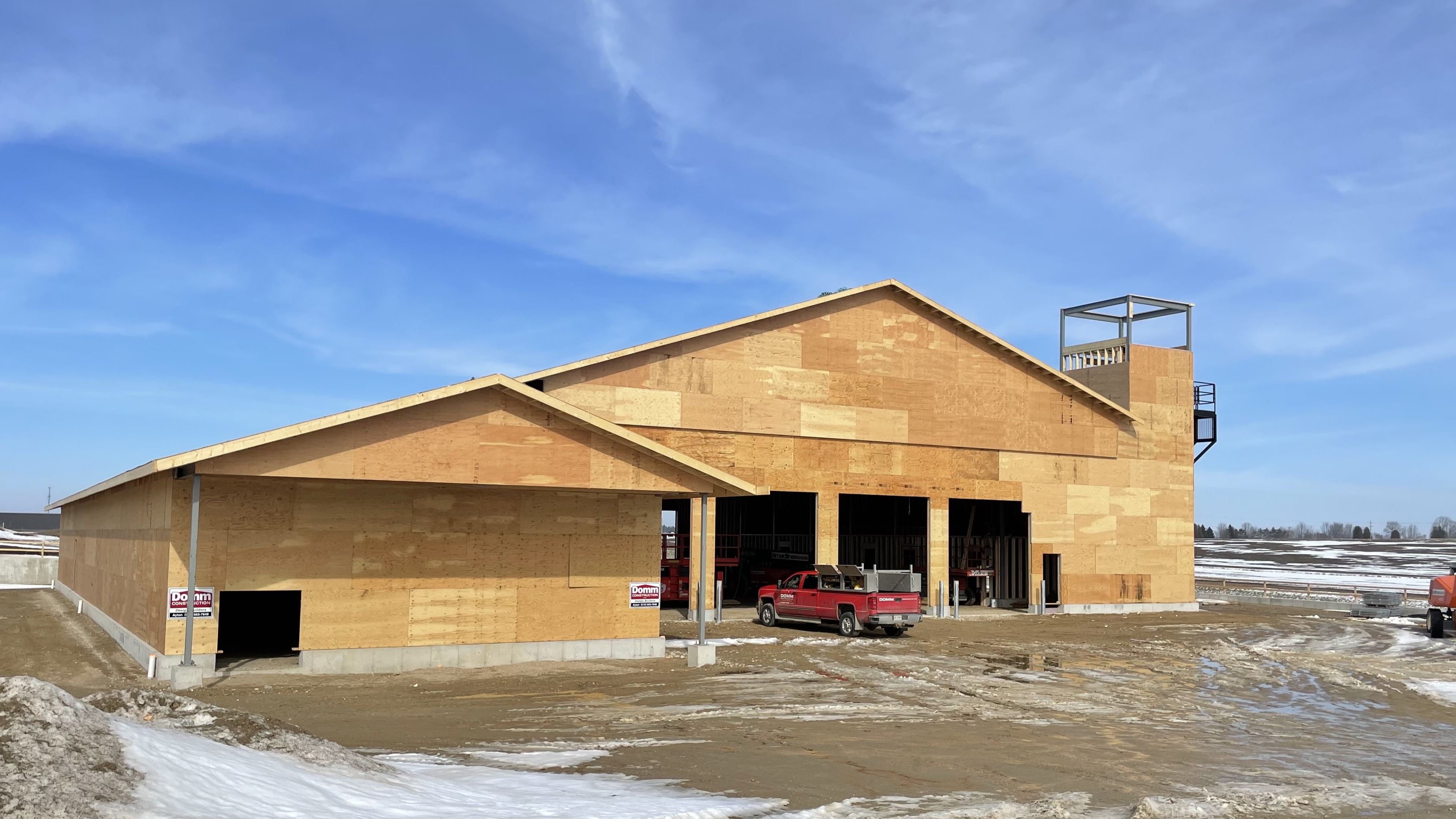 The fire hall, surrounded by unpaved ground and construction vehicles.