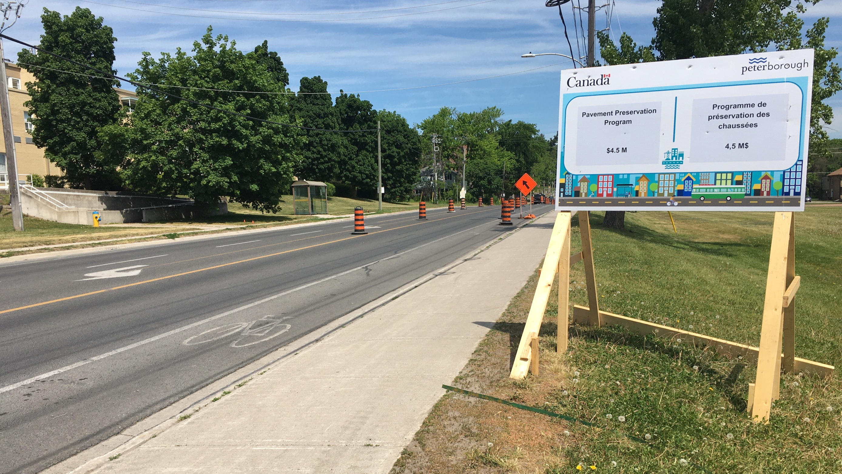 A wide shot of the road's pavement and the sign announcing this project is funded by the CCBF