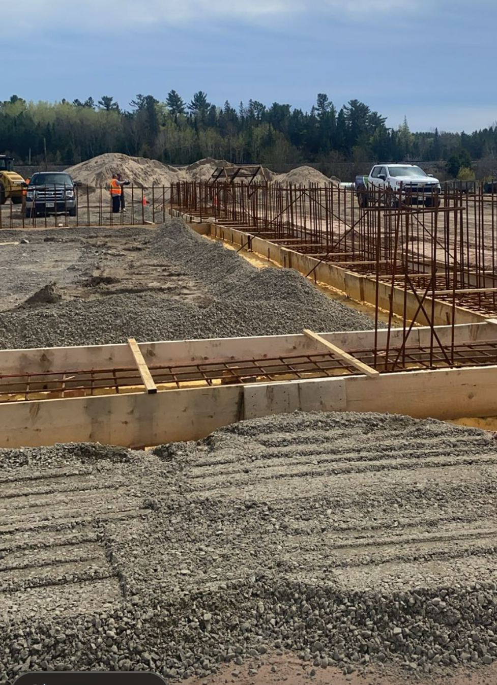 Construction workers on a work site building a sand dome. 