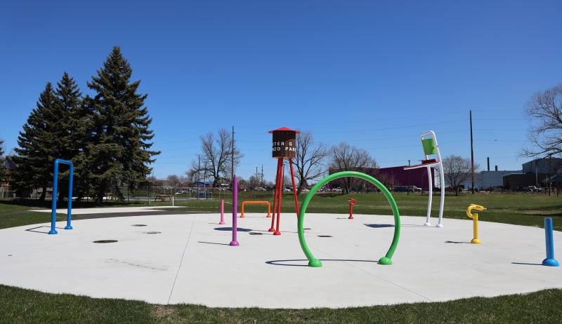 A wide shot of a splash pad, showing multiple structures that will shoot water. 