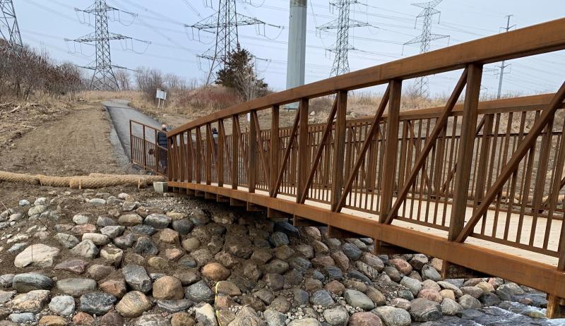 A pedestrian bridge crossing over a creek.