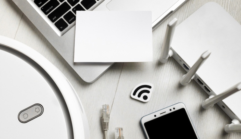 A photo showing various types of technology including a smartphone, laptop and router. 