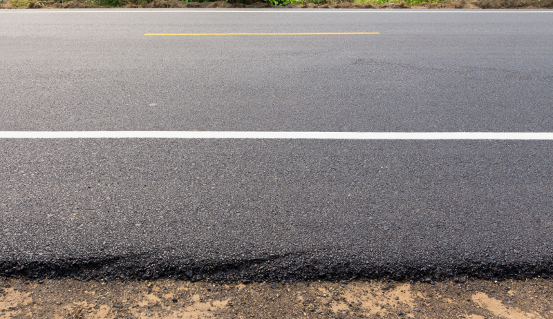 A close-up of a newly paved roadway. 