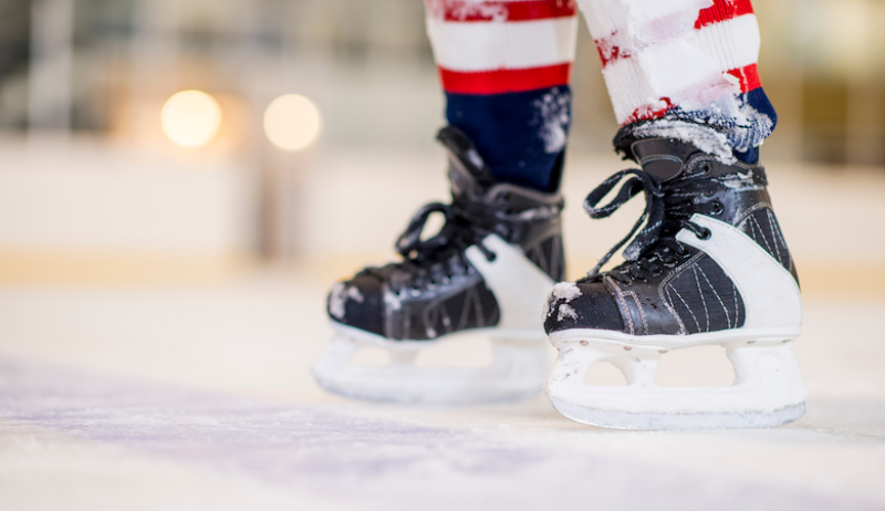 A child skating on hockey skates. 